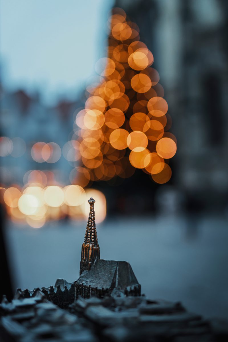 Kleines Modell der Lambertikirche, dahinter die Lichter eines Weihnachtsbaums