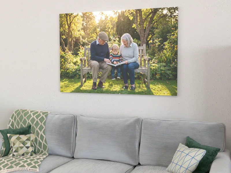 Visualisierung: Familienfoto mit Großeltern auf Holzkeilrahmen über einem Sofa, leicht von der Seite