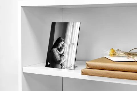 Produktansicht: Fotoaufsteller im Regal mit einem Schwarzweißfoto von Mutter und Baby