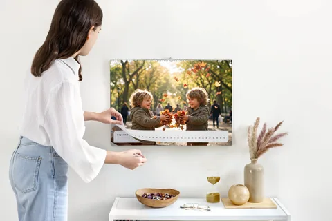 Produktansicht: Wandkalender mit einem Foto spielender Kinder im Herbstlaub