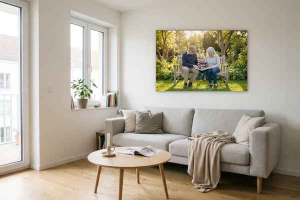 Visualisierung: Foto von Großeltern mit Enkelkind im Garten als Wandbild auf Holzkeilrahmen über einem hellgrauen Sofa