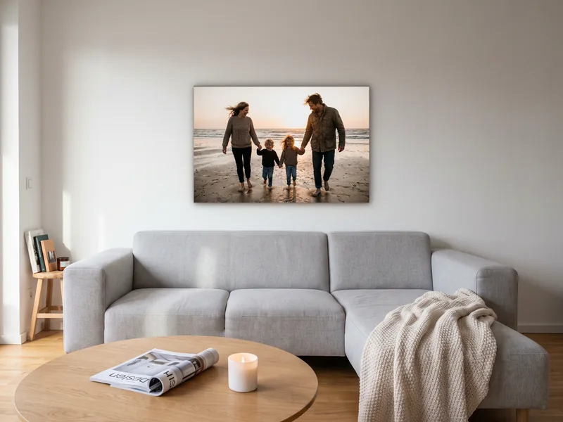 Visualisierung: ein Familienfoto vom Strand als Wandbild auf Holzkeilrahmen über einem hellgrauen Sofa