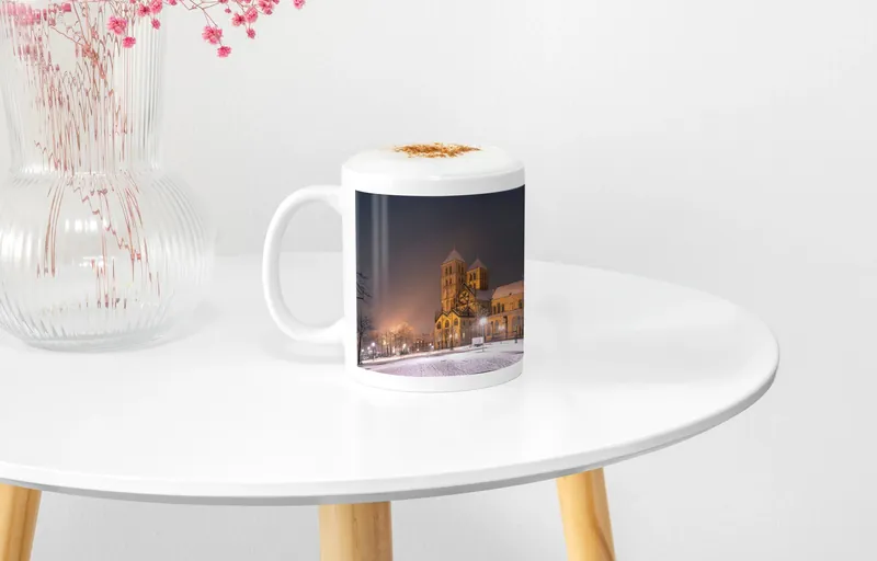 Tasse mit dem Motiv Dom im Schnee auf einem runden Beistelltisch