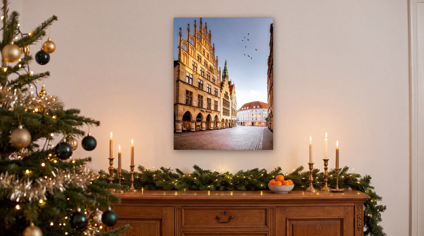 Wandbild vom Historischen Rathaus Münster über einem weihnachtlich geschmückten Sideboard mit Kerzen und Tannengrün