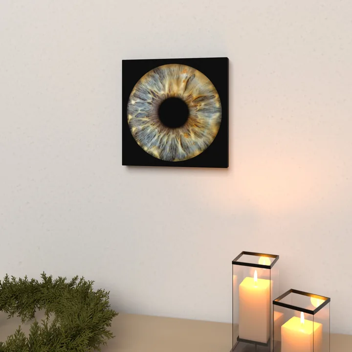 Wandbild 20 × 20 cm auf Holzkeilrahmen mit einer blau-goldenen Iris auf schwarzem Grund, an einer hellen Wand über einem Lowboard mit Tannenkranz und Windlichtern (Visualisierung)