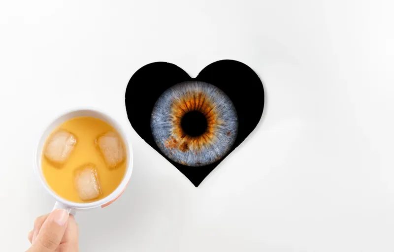 Irisbild als herzförmiger Untersetzer neben einem Glas Orangensaft