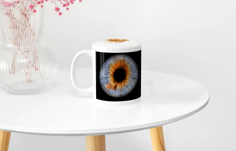 Irisbild auf einer weißen Tasse auf einem runden Beistelltisch