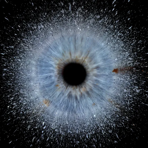 Eine blaugraue Iris, aus der feiner Staub nach allen Seiten sprüht, auf Schwarz – Iris-Wandbild Artikel 0165, Explosion