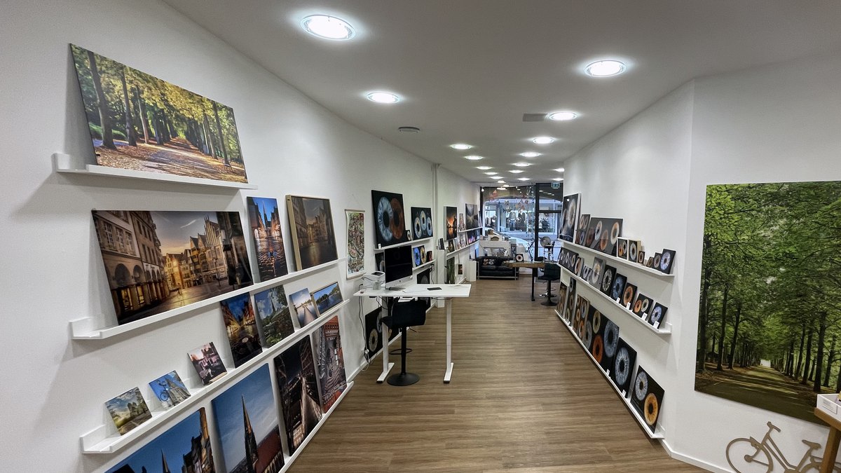 Blick durch das JALES-Ladenlokal in Münster: links Münsterbilder auf Bilderleisten, rechts eine Wand mit Irisbildern