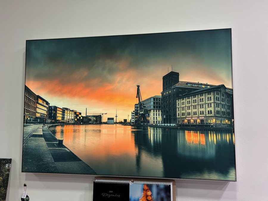 Eingeschaltetes Leuchtbild an der Wand: Stadthafen Münster mit Wolfgang-Borchert-Theater im Sonnenuntergang (Motiv: © Sascha Talke)