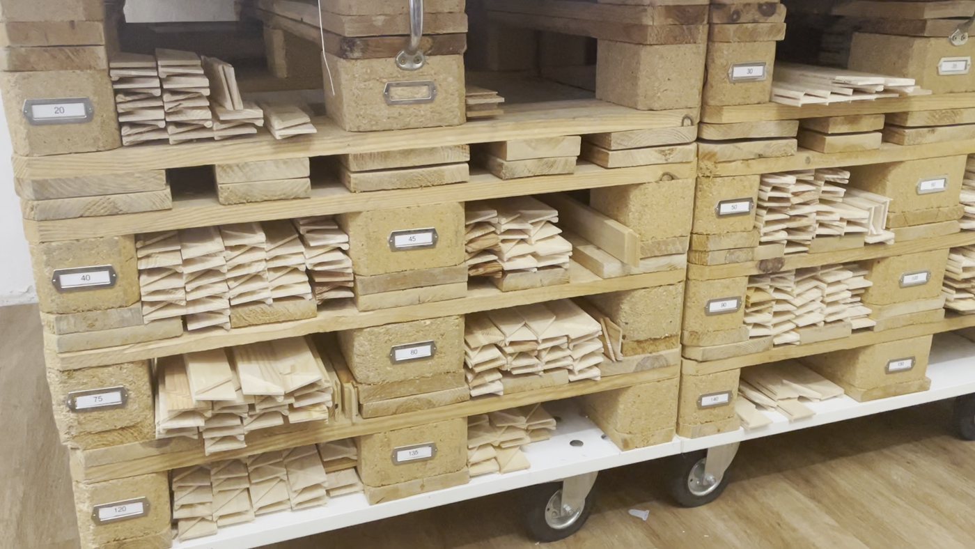 Leistenlager in der Werkstatt: Holzleisten nach Längen sortiert in beschrifteten Fächern