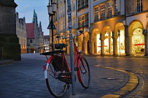 Rotes Fahrrad unter den Arkaden – Münster-Motiv von Birgit Leimann