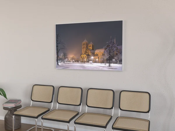 Visualisierung: Alu-Wechselrahmen 120 × 80 cm mit schmalem silbernem Profil über einer Stuhlreihe im Wartezimmer, Motiv Dom im Schnee