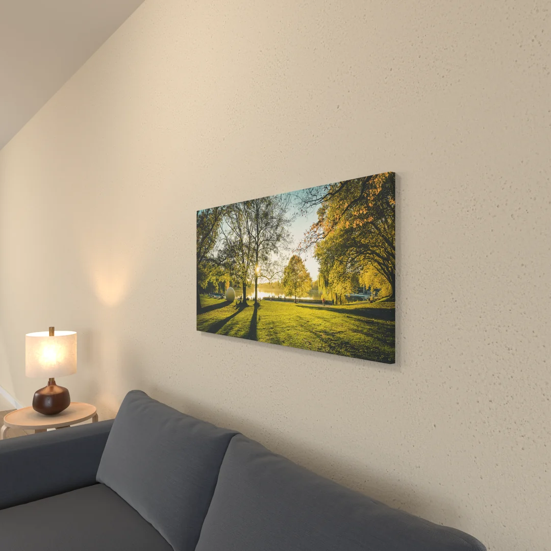 Visualisierung: fertiger Holzkeilrahmen mit dem Motiv Aaseekugeln im Herbstlicht über einem Sofa, leicht von der Seite, sodass die umgeschlagene Kante zu sehen ist